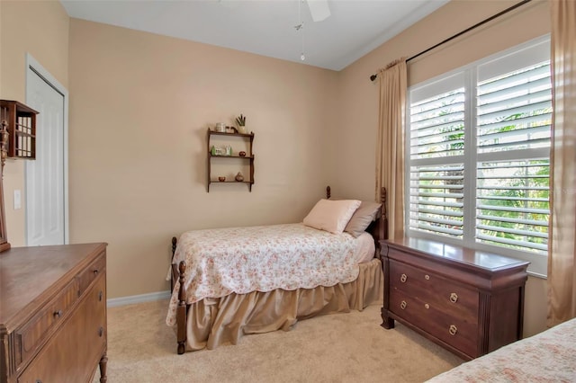 bedroom featuring multiple windows, light carpet, and ceiling fan