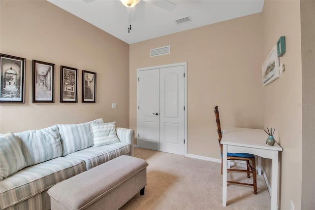living room with light colored carpet, ceiling fan, and baseboards