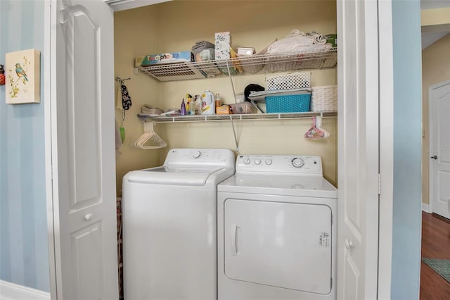 washroom with washer and dryer, wood finished floors, and baseboards