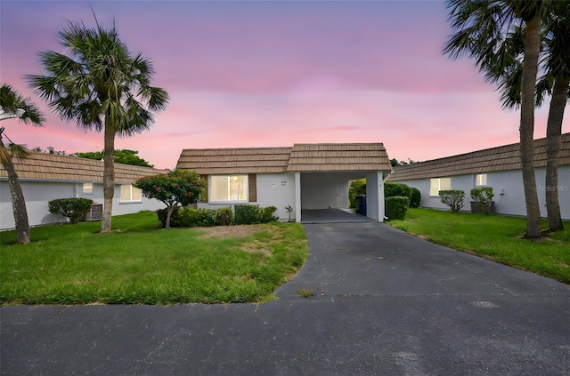 2733 Riverbluff Pl Unit V57, Sarasota, FL 34231 - front facade with a lawn, mansard roof, asphalt driveway, and a carport