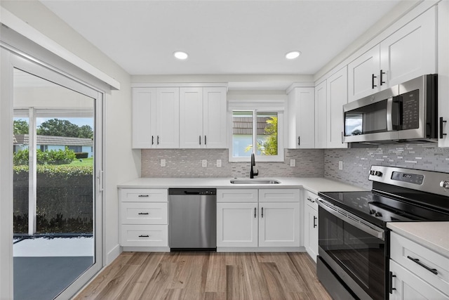 2733 Riverbluff Pl Unit V57, Sarasota, FL 34231 - kitchen featuring appliances with stainless steel finishes, light wood-style flooring, light countertops, tasteful backsplash, and recessed lighting