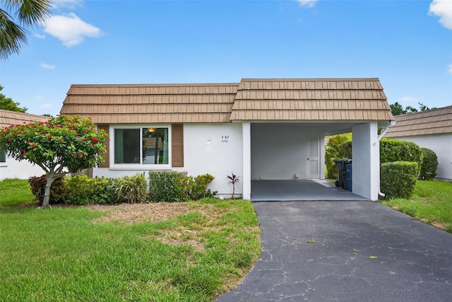 2733 Riverbluff Pl Unit V57, Sarasota, FL 34231 - front of property with an attached carport, mansard roof, stucco siding, and asphalt driveway