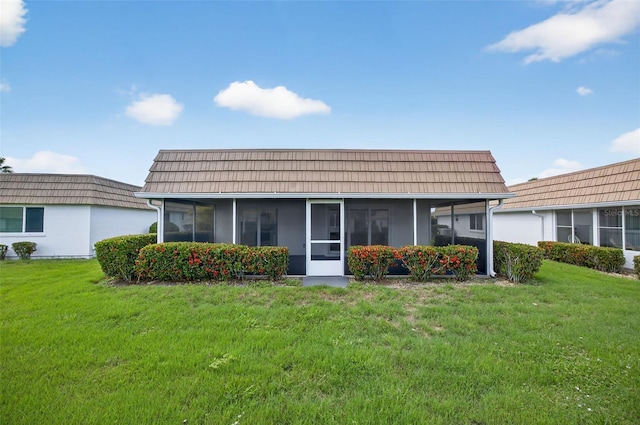 2733 Riverbluff Pl Unit V57, Sarasota, FL 34231 - rear view of property with a sunroom, a lawn, and mansard roof