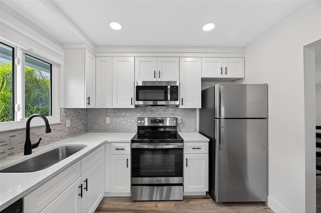 2733 Riverbluff Pl Unit V57, Sarasota, FL 34231 - kitchen featuring appliances with stainless steel finishes, light countertops, white cabinetry, and recessed lighting