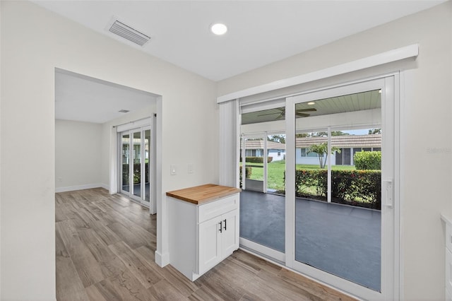 2733 Riverbluff Pl Unit V57, Sarasota, FL 34231 - kitchen featuring wood counters, plenty of natural light, light wood-type flooring, white cabinetry, and recessed lighting