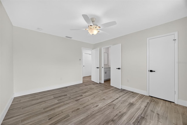 2733 Riverbluff Pl Unit V57, Sarasota, FL 34231 - unfurnished bedroom with light wood finished floors, ceiling fan, and ensuite bathroom
