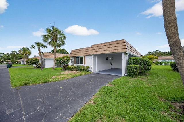 2733 Riverbluff Pl Unit V57, Sarasota, FL 34231 - view of property with mansard roof, a front lawn, driveway, and a carport