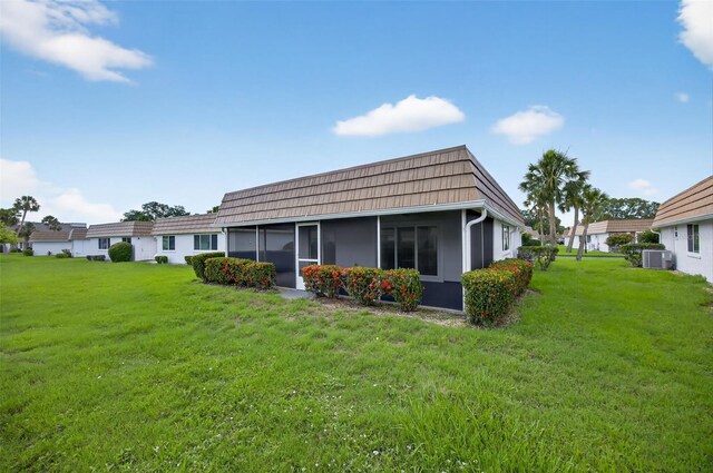 2733 Riverbluff Pl Unit V57, Sarasota, FL 34231 - back of property featuring a sunroom, a yard, and mansard roof