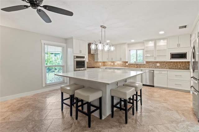 911 Cimarron Cir, Bradenton, FL 34209 - kitchen featuring stainless steel appliances, stone tile flooring, decorative backsplash, a breakfast bar area, and recessed lighting