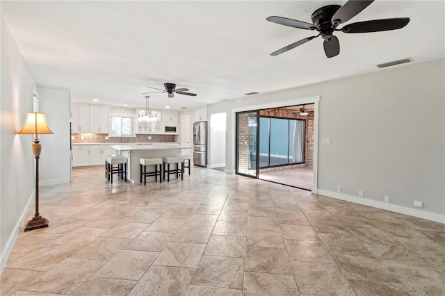 911 Cimarron Cir, Bradenton, FL 34209 - living area with ceiling fan, recessed lighting, light stone finish flooring, and a chandelier