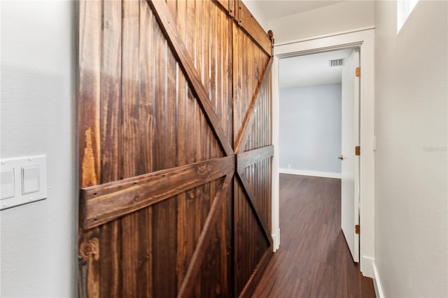 911 Cimarron Cir, Bradenton, FL 34209 - corridor featuring dark wood-type flooring and a barn door