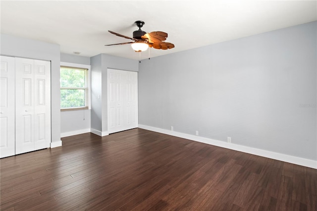 911 Cimarron Cir, Bradenton, FL 34209 - unfurnished bedroom with two closets, dark wood finished floors, and a ceiling fan