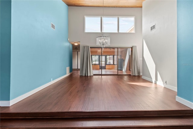 911 Cimarron Cir, Bradenton, FL 34209 - unfurnished living room featuring a chandelier, a towering ceiling, wood finished floors, and wood ceiling