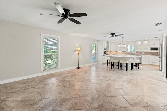 911 Cimarron Cir, Bradenton, FL 34209 - living area featuring plenty of natural light, ceiling fan, and light stone finish floors