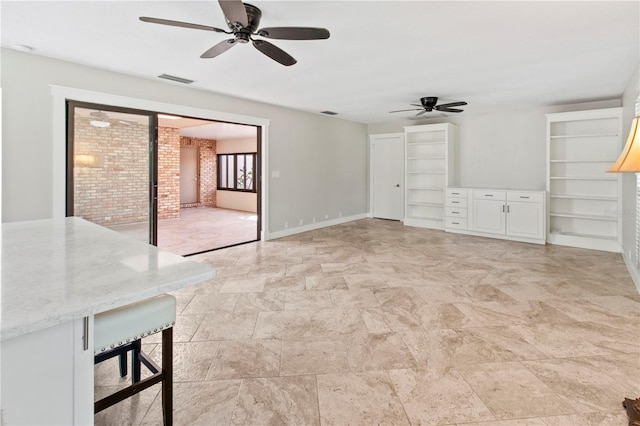 911 Cimarron Cir, Bradenton, FL 34209 - unfurnished living room featuring a ceiling fan and light stone finish floors