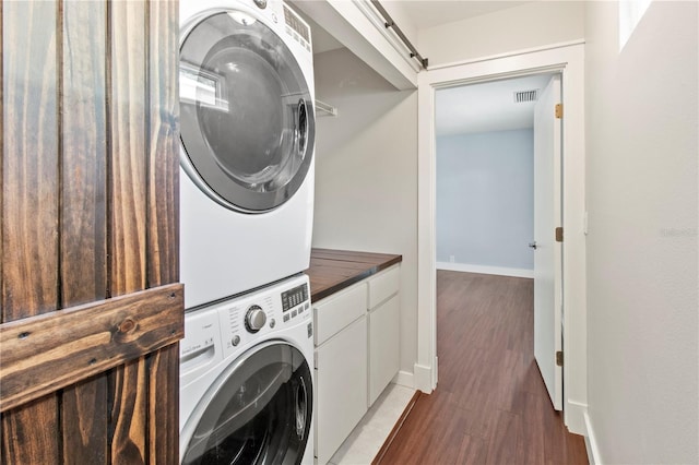 911 Cimarron Cir, Bradenton, FL 34209 - laundry room featuring stacked washing machine and dryer, light wood-style flooring, and cabinet space