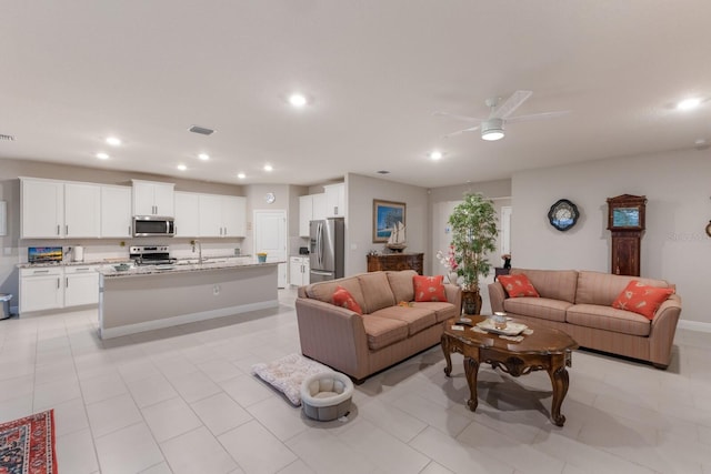 living room with recessed lighting, ceiling fan, light tile patterned floors, and baseboards