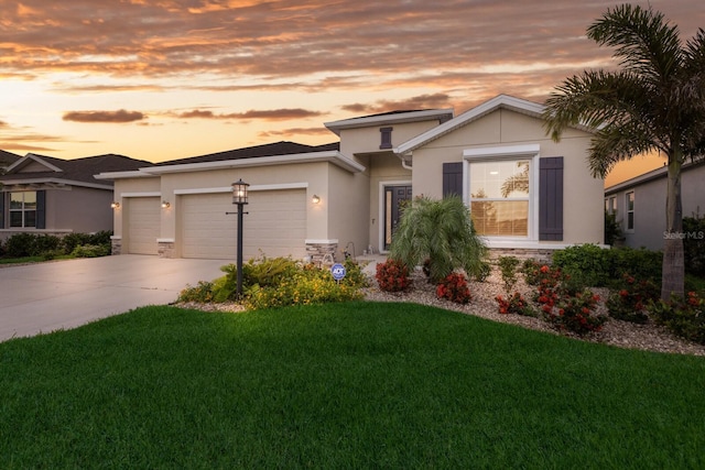 view of front of home featuring stone siding, a garage, concrete driveway, a yard, and stucco siding