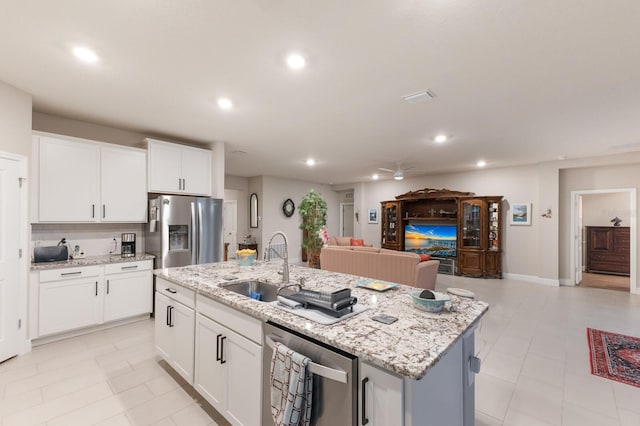 kitchen featuring appliances with stainless steel finishes, a sink, open floor plan, a ceiling fan, and recessed lighting