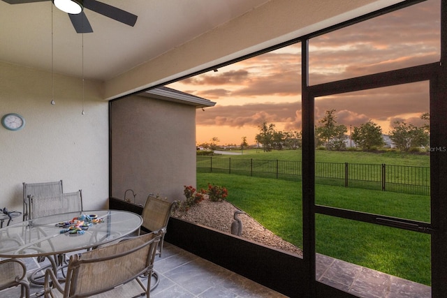 sunroom / solarium featuring outdoor dining area and a ceiling fan