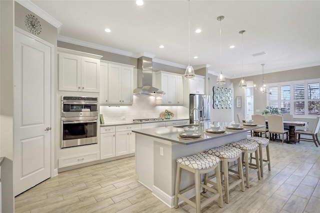 13918 Old Creek Ct, Parrish, FL 34219 - kitchen with wall chimney range hood, appliances with stainless steel finishes, a center island with sink, tasteful backsplash, and a breakfast bar