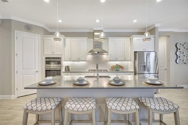 13918 Old Creek Ct, Parrish, FL 34219 - kitchen with wall chimney range hood, stainless steel appliances, a breakfast bar area, white cabinets, and ornamental molding