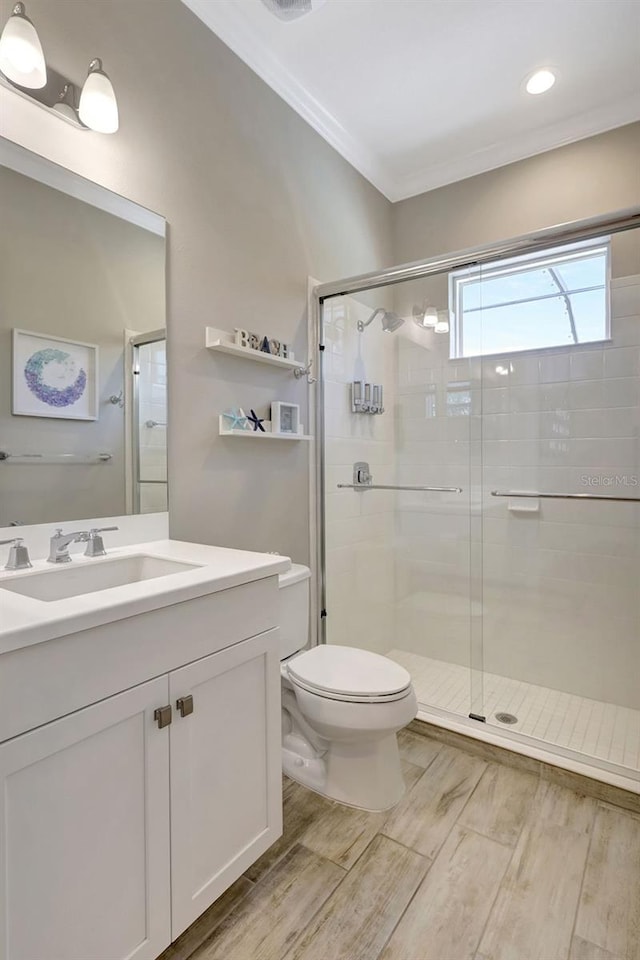 13918 Old Creek Ct, Parrish, FL 34219 - full bathroom with a stall shower, toilet, wood finished floors, crown molding, and vanity
