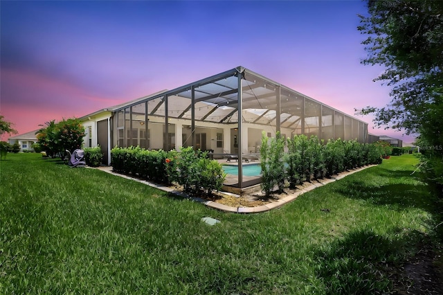 13918 Old Creek Ct, Parrish, FL 34219 - back of property at dusk featuring a lawn, an outdoor pool, and a lanai