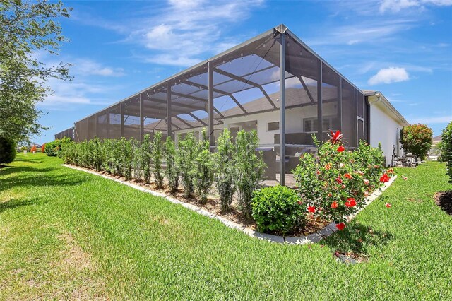 13918 Old Creek Ct, Parrish, FL 34219 - back of property featuring a lawn, glass enclosure, and stucco siding
