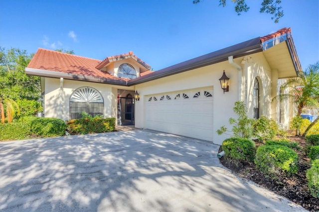 4517 Las Brisas Ln, Sarasota, FL 34238 - mediterranean / spanish-style house with stucco siding, an attached garage, driveway, and a tiled roof