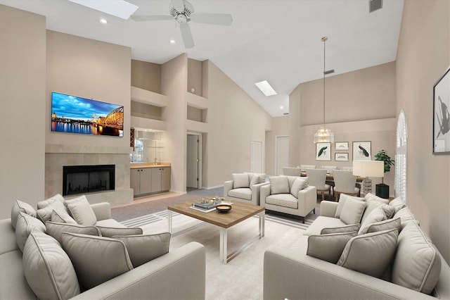 4517 Las Brisas Ln, Sarasota, FL 34238 - living area with high vaulted ceiling, a ceiling fan, light carpet, a skylight, and a tile fireplace
