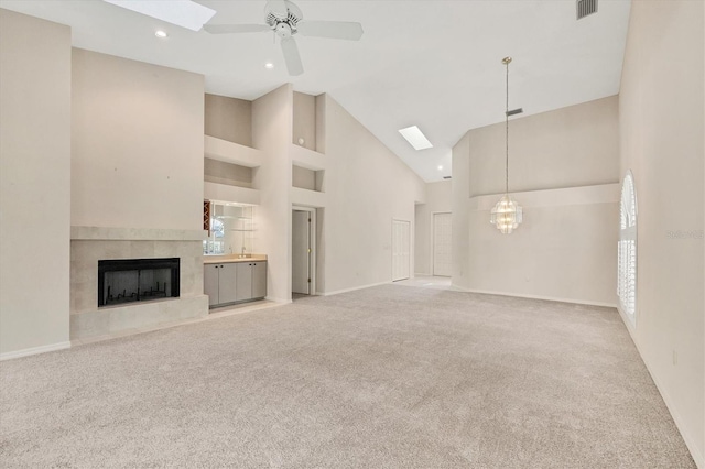4517 Las Brisas Ln, Sarasota, FL 34238 - unfurnished living room featuring carpet floors, high vaulted ceiling, ceiling fan, a fireplace, and a chandelier