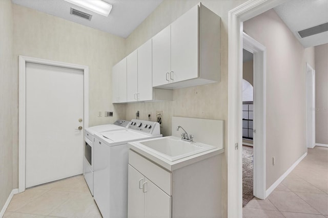4517 Las Brisas Ln, Sarasota, FL 34238 - washroom featuring washer and dryer, light tile patterned floors, cabinet space, and baseboards