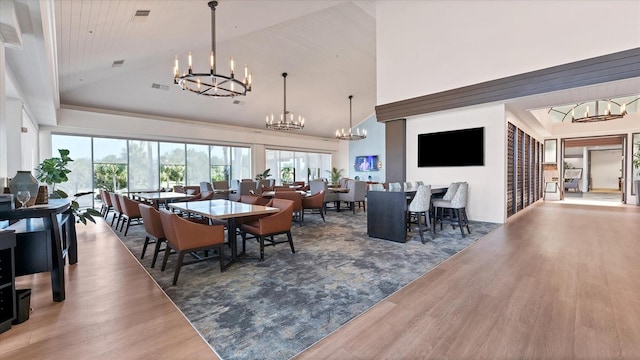 4517 Las Brisas Ln, Sarasota, FL 34238 - dining area featuring a chandelier, high vaulted ceiling, and wood finished floors