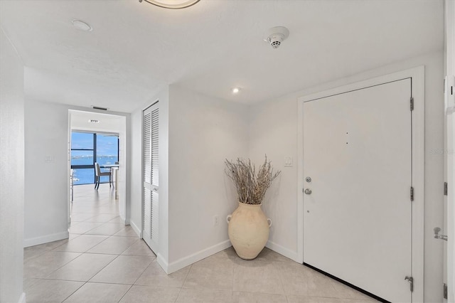 entryway with baseboards and light tile patterned flooring