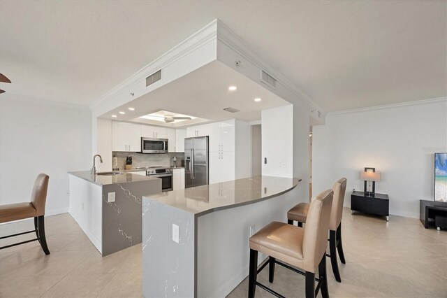 kitchen with stainless steel appliances, a peninsula, ornamental molding, backsplash, and light tile patterned flooring