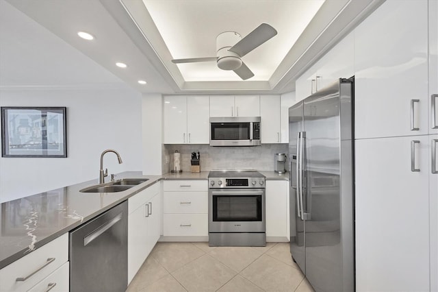 kitchen with stainless steel appliances, a sink, light tile patterned floors, ceiling fan, and decorative backsplash