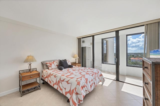 bedroom with access to outside, light tile patterned floors, and baseboards
