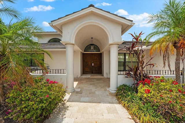 doorway to property featuring stucco siding and a porch