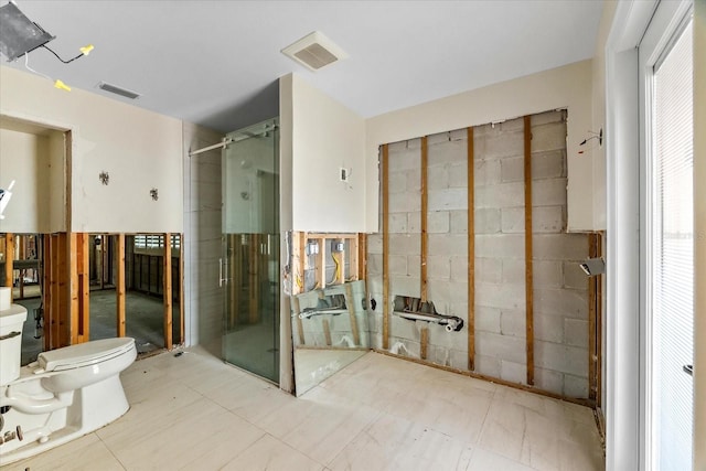 bathroom with toilet and a stall shower