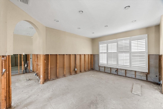 spare room featuring arched walkways