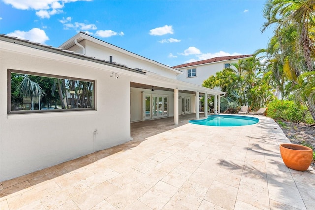 swimming pool featuring a patio area, a ceiling fan, and french doors