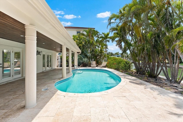 outdoor pool featuring french doors and a patio area