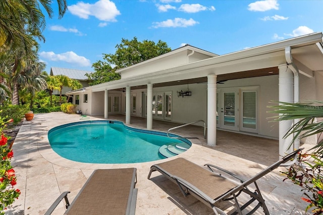 outdoor pool with french doors, a patio area, and ceiling fan