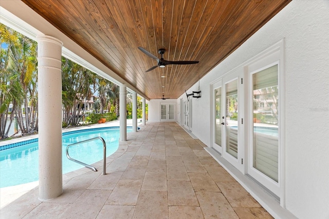 outdoor pool with french doors, a ceiling fan, and a patio