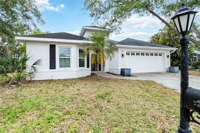 view of front facade with a garage, stucco siding, concrete driveway, and a front lawn