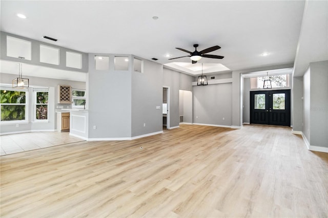unfurnished living room with recessed lighting, light wood-type flooring, a ceiling fan, baseboards, and a chandelier