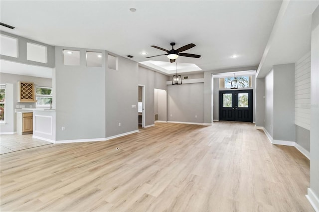 unfurnished living room with plenty of natural light, recessed lighting, light wood-style flooring, a chandelier, and ceiling fan