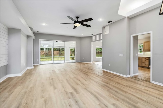 unfurnished living room featuring ceiling fan, light wood-style flooring, baseboards, and recessed lighting