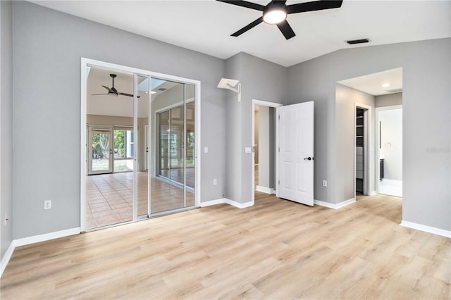unfurnished bedroom featuring vaulted ceiling, wood finished floors, baseboards, and ceiling fan